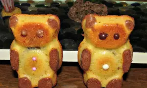 Deux oursons en gâteau, parfaits pour une recette ourson chocolat. Ils ont des yeux en chocolat et des boutons roses ou blancs.