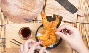 Chrupiące krewetki w cieście tempura na ryżu, gotowe do spożycia. Idealny przepis na tempurę.