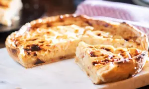 Ein köstliches Quiche Rezept, goldbraun gebacken, mit einem Stück zum Probieren.
