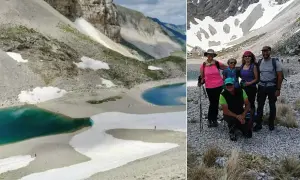 Gruppo di escursionisti al lago di Pilato, con le sue acque turchesi e i nevai circostanti.