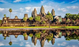 Piękna kambodża pogoda nad Angkor Wat. Lotosowy staw odbija majestatyczne wieże świątyni w błękitnym niebie z chmurami.