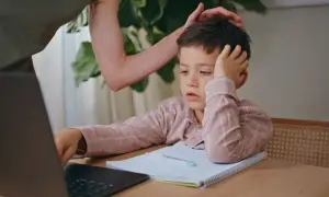 Chłopiec z rezygnacją opiera głowę na dłoni, wyraźnie widać, że dziecko nie chce się uczyć.