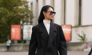 Stilvolles Outfit: Schwarzer Blazer über einem weißen Hemd mit Rollkragen kombinieren. Modische Sonnenbrille und goldene Ohrringe runden den Look ab.