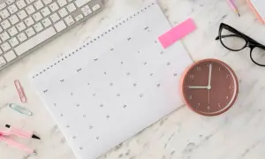 Biurko z kalendarzem, klawiaturą i zegarem. Czy sobota i niedziela wlicza się do urlopu? Czas pokaże.