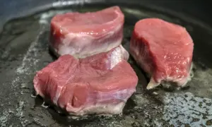 Drei saftige Schweinefilet-Medaillons braten in einer heißen Pfanne. Perfekt für köstliche Schweinefilet Rezepte.