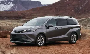 Szara Toyota Sienna na tle pustynnego krajobrazu z czerwonymi skałami.