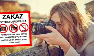 Kobieta z aparatem ignoruje znak zakaz fotografowania.