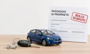 Chiavi e auto blu su un tavolo, con un documento di passaggio di proprietà e un timbro "Bollo scaduto". Ideale per chi acquista un'auto usata.