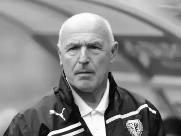 Portret siwowłosego mężczyzny, lenczyk trener piłkarski, w kurtce sportowej z logo Puma.