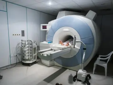 Gabinet rezonansu magnetycznego. Pacjent leży na stole aparatu MRI, przygotowany do badania. Sprawdź rezonans magnetyczny - cennik.