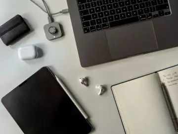 Staż pracy umowa zlecenie: laptop, tablet, słuchawki i notatnik z listą zadań.