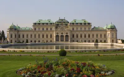 Barokowy pałac Belweder w Wiedniu, z zielonymi kopułami i ogrodem. Idealne miejsce na zakup biletów i zwiedzanie.