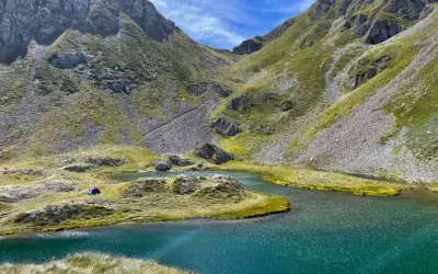 Un accampamento solitario ai laghetti di Ponteranica, tra montagne verdi e acque cristalline.