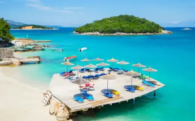 Rajskie albania plaże z turkusową wodą, leżakami i parasolami. Idealne miejsce na relaks.