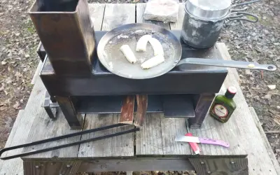 Poêle rocket fait maison, avec des bananes qui dorent dans une poêle, une marmite et une bouteille de rhum Negrita.