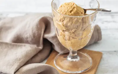 Cremiges Baileys mit Vanilleeis in einem Glas, serviert mit einem Löffel. Ein Leckerbissen für warme Tage.