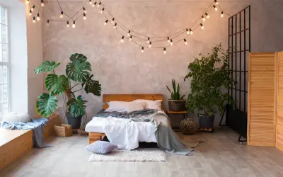 Przytulna sypialnia boho loft z łóżkiem, roślinami i girlandą świetlną.