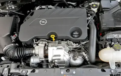 Silnik 2.0 Turbo w Oplu Insignia, gotowy do pracy. Widoczny turbosprężarka i osłony.
