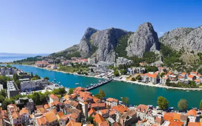 Widok na miasto Omis w Chorwacji z rzeką Cetina i górami w tle.