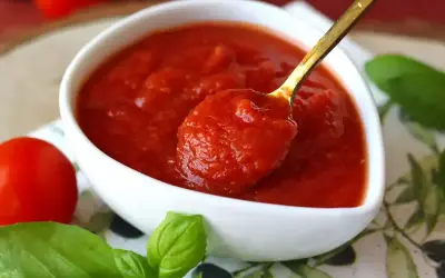 Gęsty, domowy sos do makaronu, z pomidorów i bazylii, gotowy do podania.