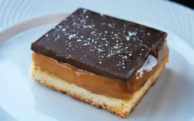 Idealne ciasto milionera: kruchy spód, ciągnący karmel i czekoladowa polewa posypana solą. Prawdziwy deserowy skarb!