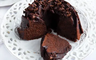 Pyszna babka z mascarpone i kakao, polana czekoladą i posypana wiórkami. Idealna na deser.