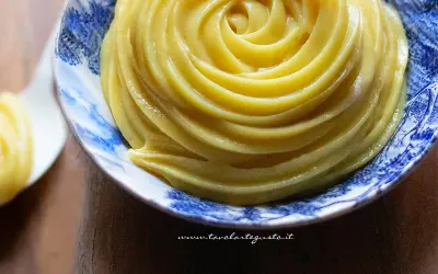 Crema pasticcera senza uova, liscia e vellutata, servita in una ciotola decorata con motivi blu.