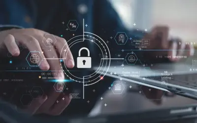 Ręce pracujące nad technologią, symbol kłódki i ikony sieciowe podkreślają znaczenie cyber security.