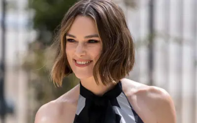 Une femme souriante, la cinquantaine, arbore une coupe dégradée qui donne du volume à ses cheveux fins et plats.
