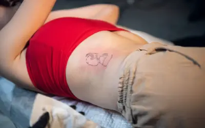 Nowy tatuaż na żebrach, przedstawiający abstrakcyjną postać.