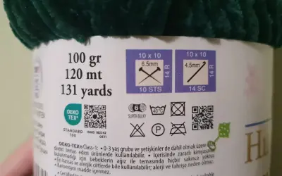 Etykieta z informacjami o różnych rodzajach włóczek: 100g, 120m, 131 jardów. Wskazówki dotyczące rozmiaru drutów i oczek. Certyfikat OEKO-TEX®.