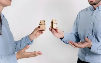 Rozdzielność majątkowa a wspólny dom: dwoje ludzi trzyma miniaturowe domki, symbolizujące podział majątku.