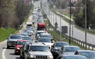 Korek na drodze, jak węzeł gordyjski, zablokował ruch. Samochody stoją w długiej kolejce, tworząc niekończący się rząd pojazdów.