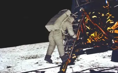 Astronaut schodzi po drabinie modułu księżycowego, rozpoczynając historyczne lądowanie na księżycu.