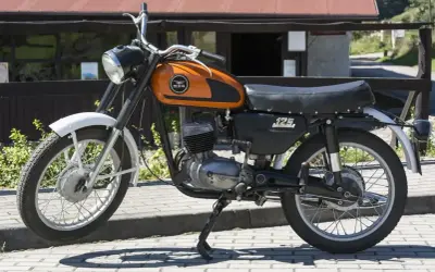 Pomarańczowy motocykl WSK 125 modele, klasyk z lat 70., gotowy do podróży.