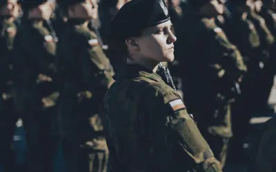 Kobieta w beretce i mundurze, gotowa do służby. To jej dobrowolna zasadnicza służba wojskowa.