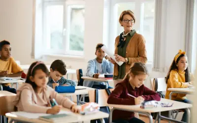 Lehrerin erklärt im Unterricht, während Schüler in Deutschland konzentriert arbeiten. Die Schulnoten sind ein wichtiger Teil des Bildungssystems.
