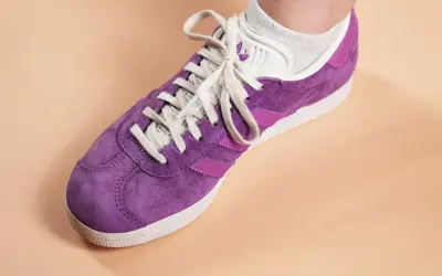 Une chaussure Adidas Gazelle violette, prête à nettoyer pour retrouver son éclat.