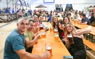 Amigos brindando con jarras de cerveza en el oktober valdespartera. Ambiente festivo y sonrisas.