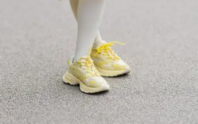 Żółte sneakersy na nogach w białych skarpetkach. Czy 36 rozmiar buta ile to cm?