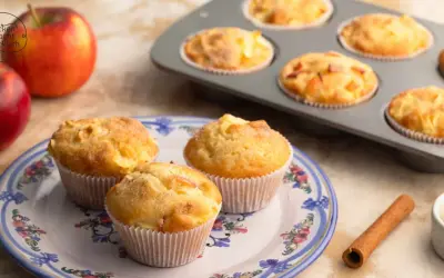 Frisch gebackene Apfelmuffins, die nach einem tollen apfelmuffins rezept duften. Daneben liegen Äpfel und Zimt.