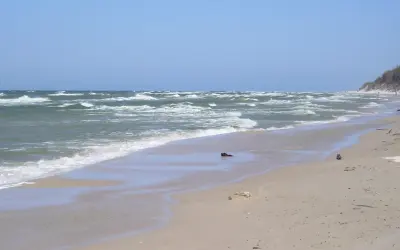 Plaża z falami i wydmami. Warto zobaczyć to miejsce, idealne na spacer i podziwianie natury.