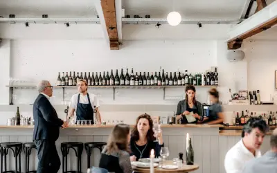 Un bar de restaurant moderne avec des employés derrière le comptoir, respectant les normes d'hygiène et de service.