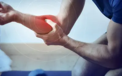 Un homme se tient le bras, une zone rouge vif sur son avant-bras indiquant une douleur. Des cercles concentriques suggèrent une gêne.