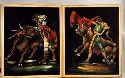 Two paintings by 1970s artists painters depict matadors facing bulls. The vibrant velvet art captures the drama of the bullfight.