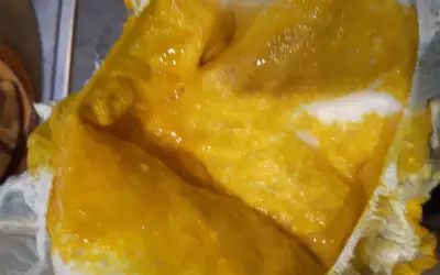Jasnożółta, papkowata kupa po mleku modyfikowanym, z widocznymi grudkami, w pieluszce.