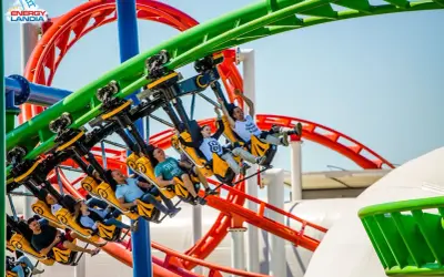 Ludzie krzyczą z radości na żółtych wagonikach rmf dragon roller coaster w Energylandii.