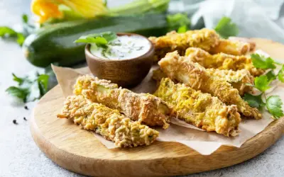 Chrupiące frytki z cukinii w panierce panko, podane z sosem. Idealna przekąska, która udowadnia, że frytki z cukinii można zrobić w panierce panko.