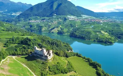 Castello di Tione, vigneti e lago in Val di Non. Un panorama mozzafiato, ideale per scoprire cosa vedere in questa valle incantevole.