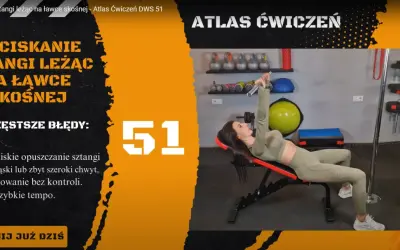 Kobieta wykonuje wyciskanie sztangi leżąc na ławce skośnej. Ćwiczenie numer 51 z atlasu ćwiczeń.